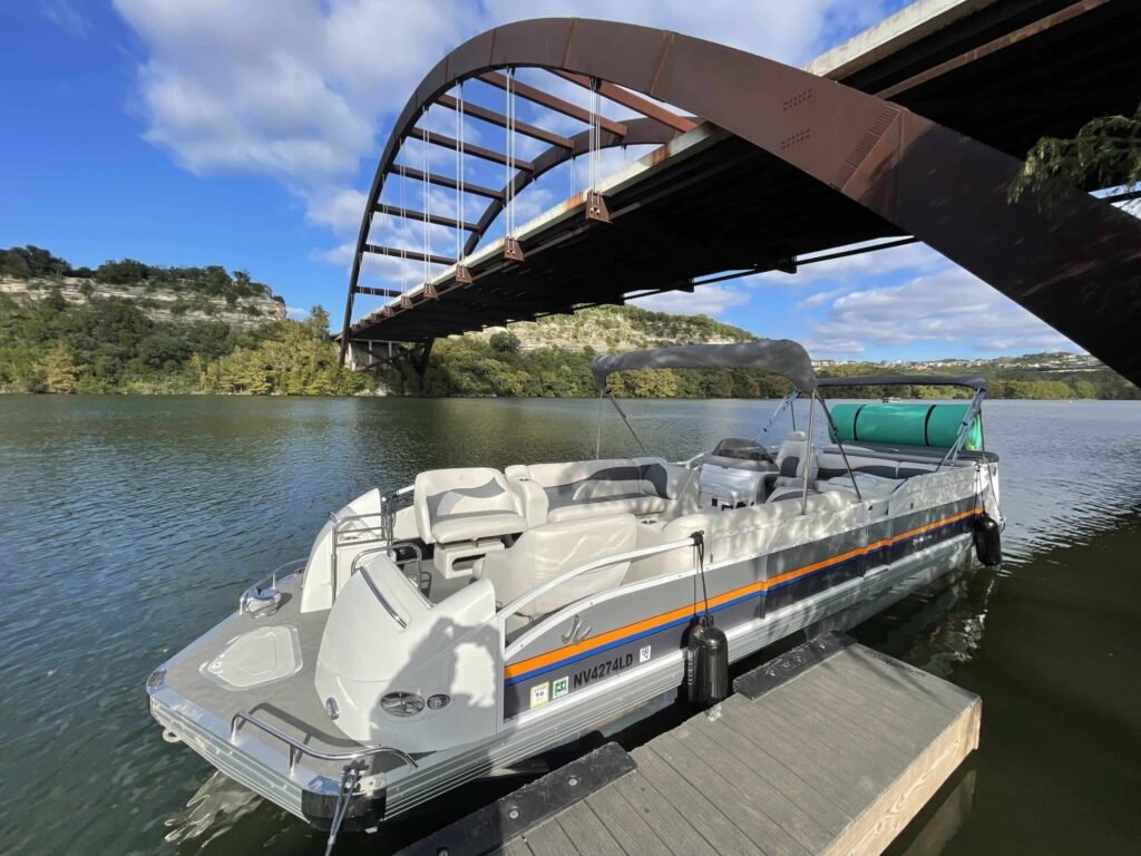 Boat cruising under Pennybacker Bridge on Lake Austin